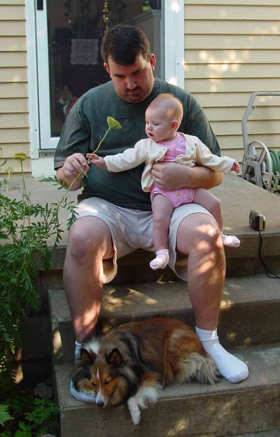 Daddy, Emily, and Ripley in front of Grandma Jan's house.