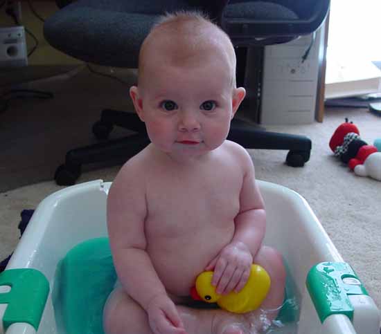 Emily is having a bath and playing with her rubber ducky.