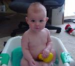 Emily is having a bath and playing with her rubber ducky.