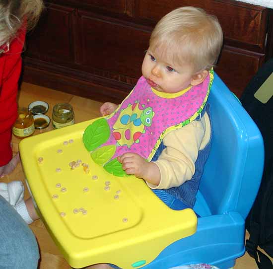 One of Kate's twins in a really cool portable high chair.