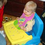 One of Kate's twins in a really cool portable high chair.